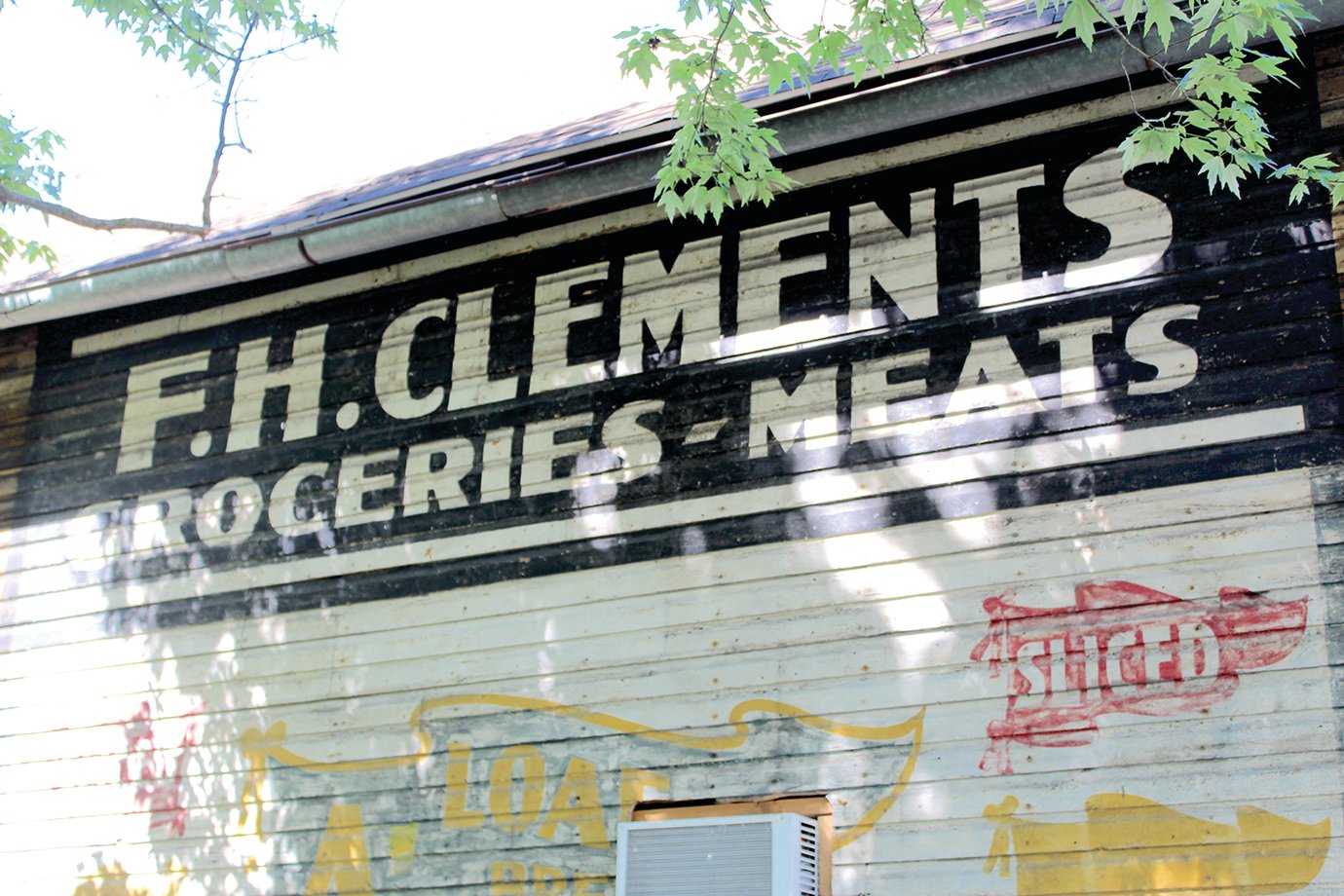 The F.H. Clements sign which emerged from under crumbling particulate siding now greets motorists heading west on East Main Street.